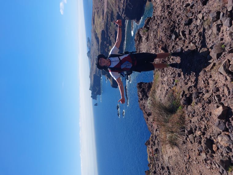 Maxi, covered in sweat, stands triumphantly on a cliff in Madeira, giving two thumbs up.