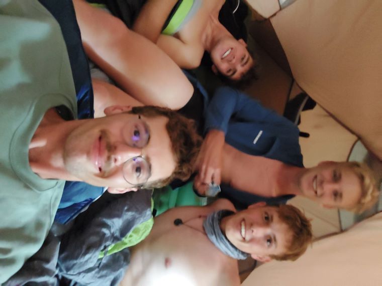 A selfie of the four boys inside a tent, all looking very happy and ready for a round of UNO.