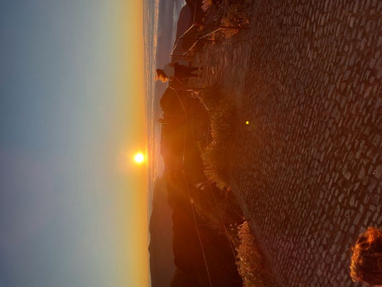 An image of the sunset on Madeira's highest peak, casting a golden glow over the surrounding landscape.