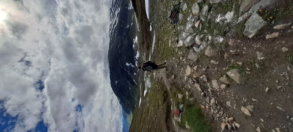 Florian hiking along the Kungsleden trail, surrounded by majestic, snow-covered mountains.