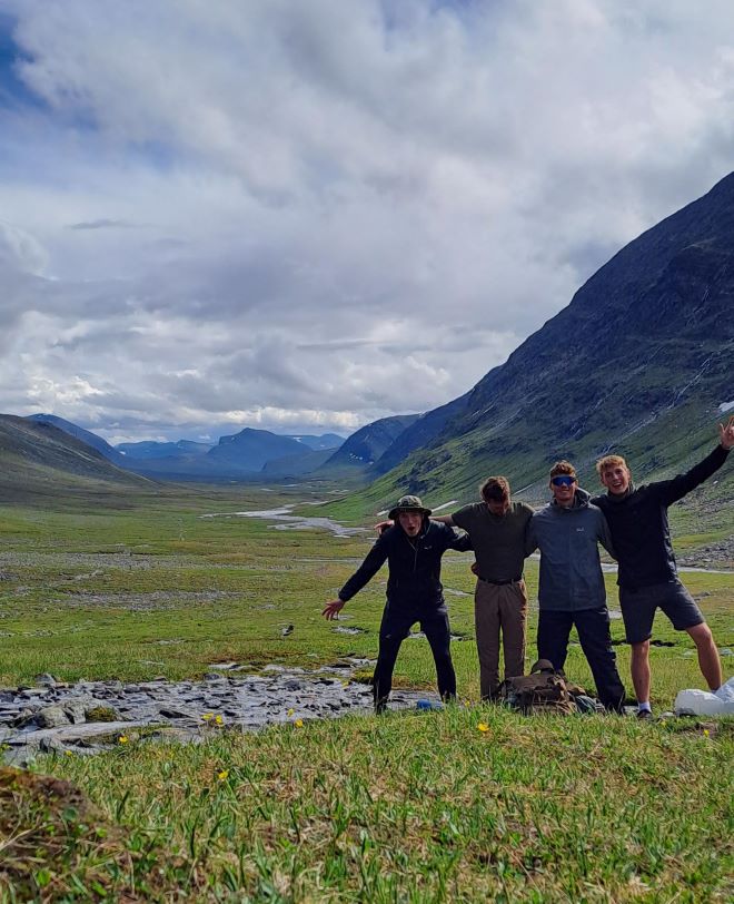 A group photo of the four boys in a valley on the Kungsleden trail, all looking very excited.