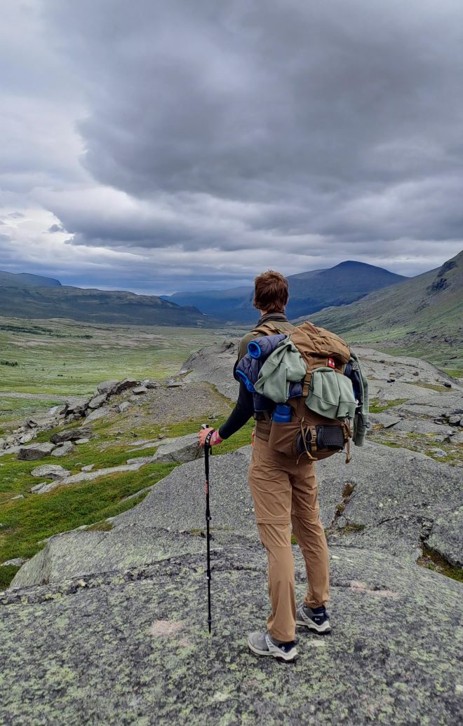 Florian looking into the distance, surveying the trail ahead as it leads through a valley.